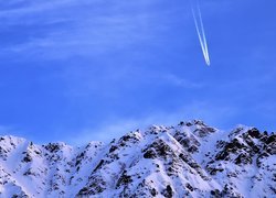 Samolot na niebie nad ośnieżonymi górami