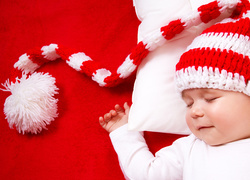 Śpiące dziecko w biało-czerwonej czapeczce