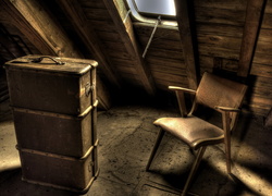 Stara walizka obok krzesła na strychu