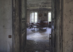 Stary zniszczony pokój z fortepianem i krzesłami