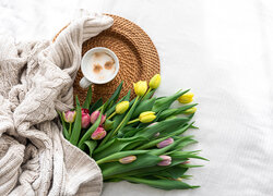 Sweter obok kolorowych tulipanów i filiżanki kawy
