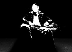 Trzymający w dłoni pistolet siedzący mężczyzna w czarno-białej grafice 2D