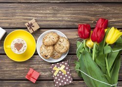 Tulipany i prezenty obok kawy i ciasteczek