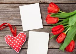 Tulipany obok kartek i serca na deskach