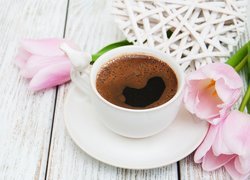 Tulipany położone obok filiżanki z kawą