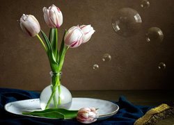 Tulipany w szklanym wazoniku na talerzu