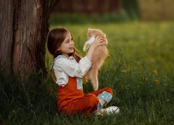 Uśmiechnięta dziewczynka z rudym kotem