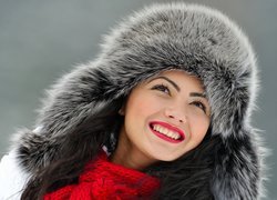 Uśmiechnięta kobieta w futrzanej czapce