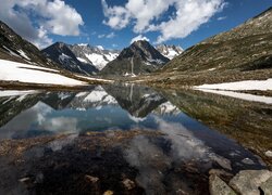 Widok znad jeziora na chmury nad górami