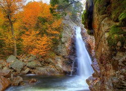 Wodospad wśród skał i jesiennych drzew