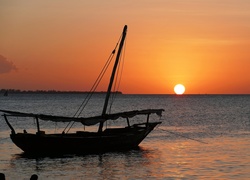 Żaglówka na morzu w świetle zachodzącego słońca