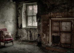 Zniszczony fotel i piec w starym opuszczonym budynku